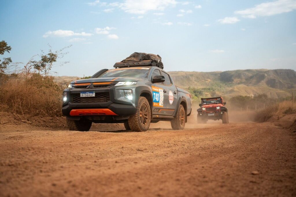 Expedition vehicles on a red dirt road in the Brazilian countryside